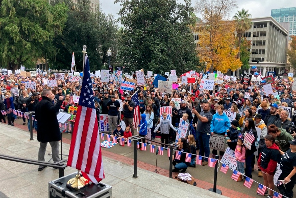 Matthew Oliver, owner of House of Oliver wine bar in Roseville, speaks to a crowd gathered at the California Capitol to protest the state's upcoming coronavirus vaccine mandate for school children