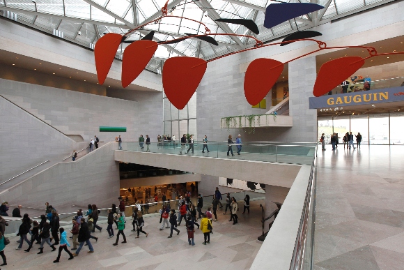 Patrons walk under an Alexander Calder mobile through the National Gallery of Art in Washington