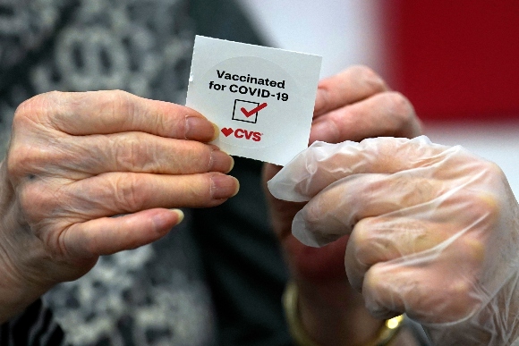 A patient receives a sticker after receiving a shot of the Moderna COVID-19 vaccine