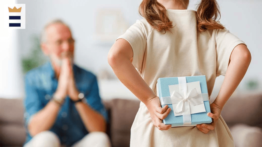 Grandchild holds blue gift behind back while grandparents waits on couch.