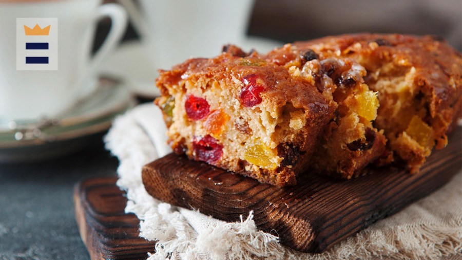 A fruitcake displayed nicely on a wooden cutting board