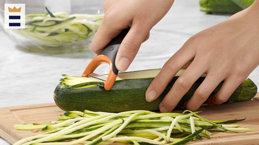 person using a gadget to slice a cucumber