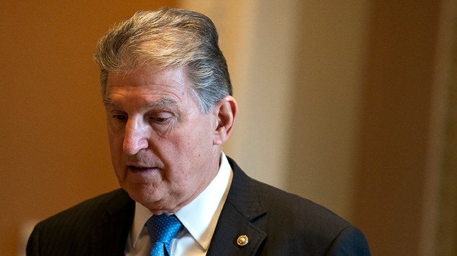 Sen. Joe Manchin (D-W.Va.) and his staff return from the Capitol Rotunda on Thursday, December 9, 2021 to pay their respects to the late Sen. Bob Dole (R-Kan.) lying in state in the Capitol Rotunda.