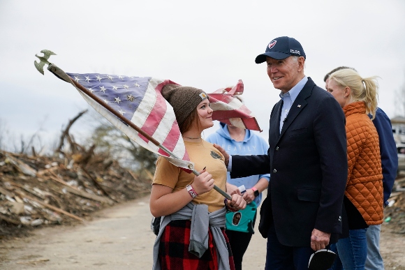 President Joe Biden speaks with Raylie Hall, 12, as he surveys storm damage from tornadoes and extreme weather in Dawson Springs, Ky.