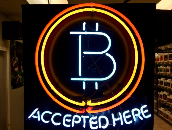 A neon sign shows that the business accepts bitcoin as payment