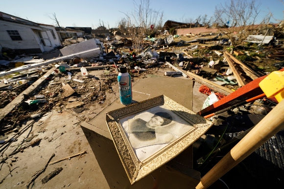 A framed photo of Martha Thomas lies among the debris of her destroyed home