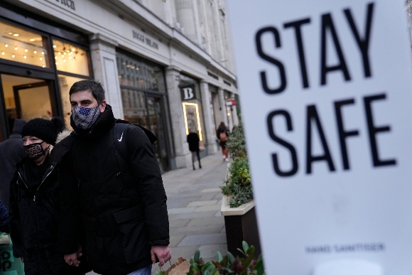 Pedestrians wearing face masks against the coronavirus walk along Regent Street in London