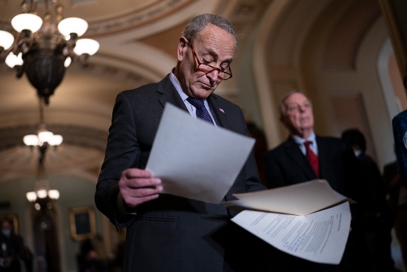 Senate Majority Leader Chuck Schumer, D-N.Y., joined at right by Majority Whip Dick Durbin, D-Ill., looks over his notes