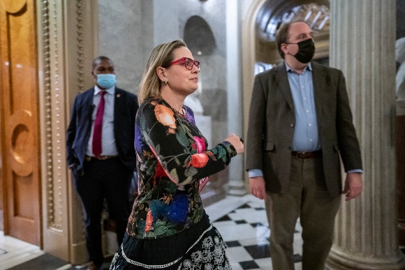 Sen. Kyrsten Sinema, D-Ariz., runs from the Senate chamber after voting on an appropriations bill