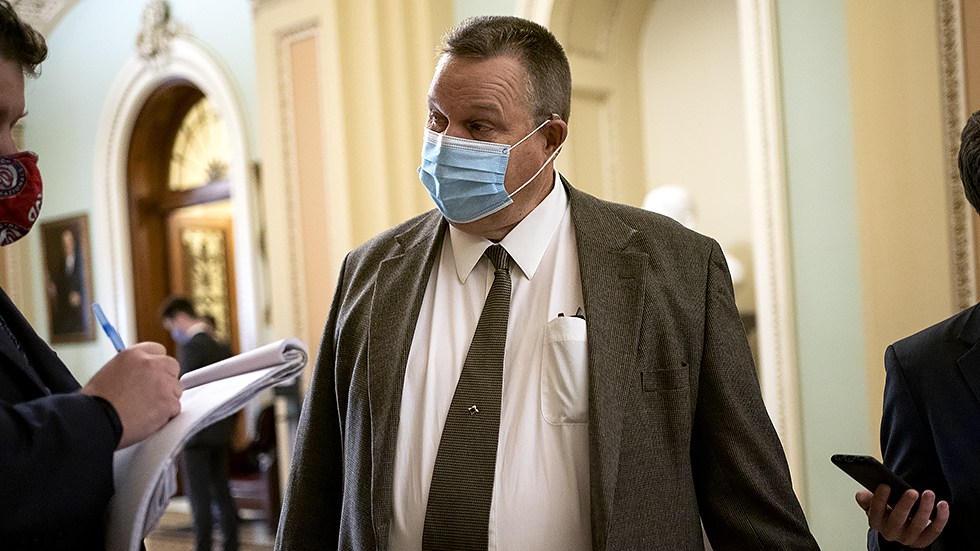 Sen. Jon Tester (D-Mont.) speaks to a reporter outside the Senate Chamber during a series of judicial nomination votes on Tuesday, October 26, 2021.