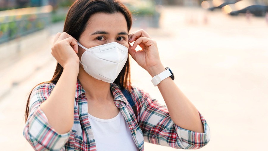 Person putting on a KN95-style face mask