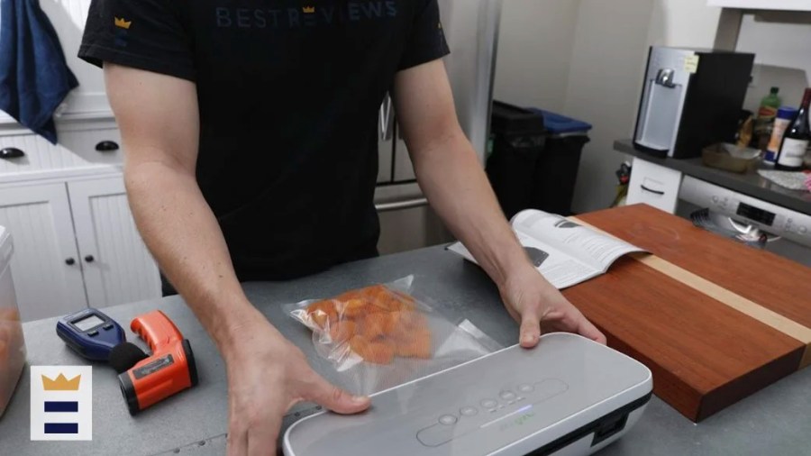 Person using a vacuum sealer in the kitchen