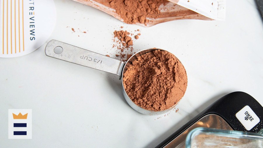 A measuring cup filled with protein powder sitting on the counter