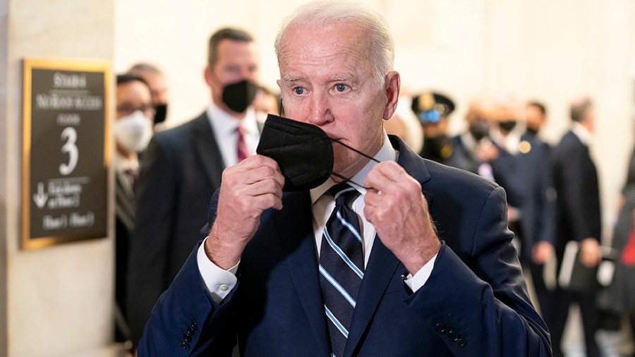 President Biden removes his mask as he speaks to reporters after a Democratic caucus luncheon at the Senate Russell Office building to discuss voting rights and filibuster reform on Thursday, January 13, 2022.