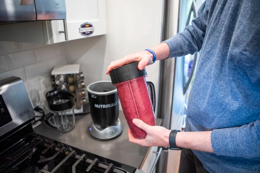 Person making a berry smoothie using a Nutri Bullet