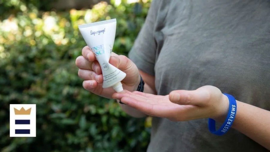 Person squeezing sunscreen from a tube into their hand