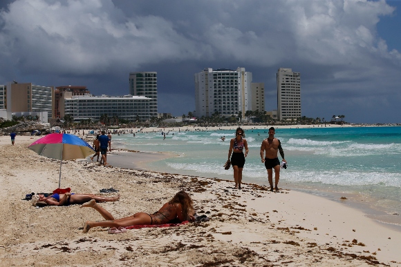 Tourists sunbathe on the beach before the arrival of Hurricane Grace, in Cancun