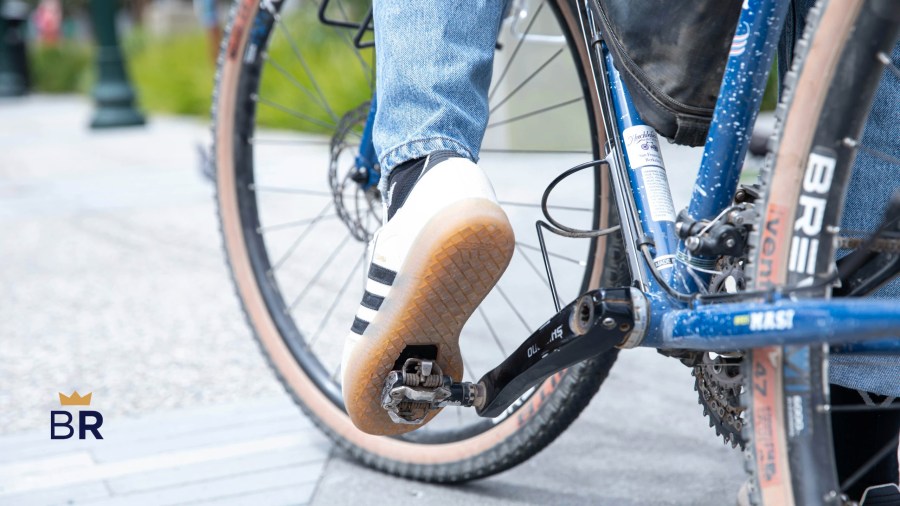 Closeup of a person's feet on the pedals of a blue bicycle