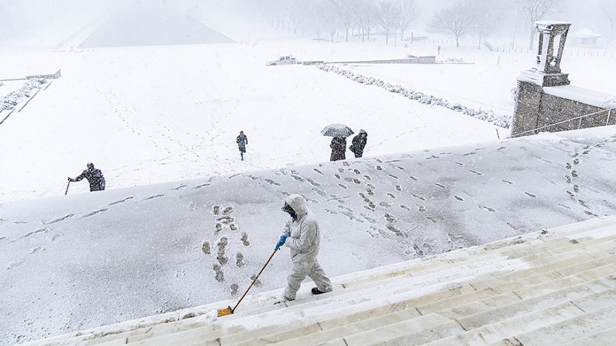 A National Park Service employee cleans the steps of the Lincoln Memorial as a winter storm hits the mid-Atlantic region covering Washington, D.C., on Monday, January 3, 2022.