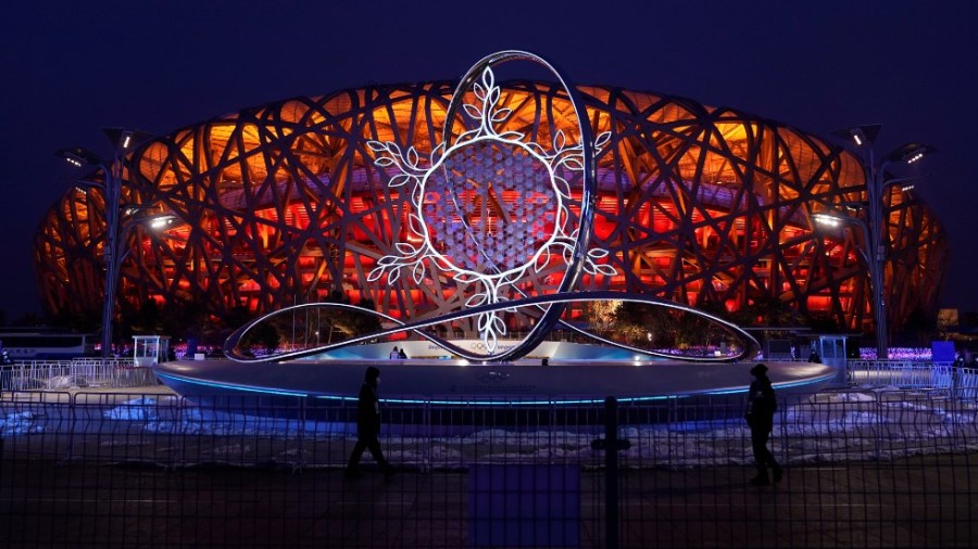 The Olympic flame burning in the center of the snowflake-shaped cauldron is on display near the National Stadium at the 2022 Winter Olympics