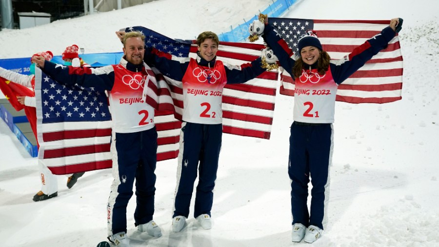 Americans Ashley Caldwell, Christopher Lillis and Justin Schoenefeld celebrate their gold medal victory in the mixed team aerials in Beijing