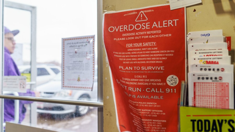 A sign calling attention to drug overdoses is posted to the door of a gas station on the White Earth reservation in Ogema, Minn.