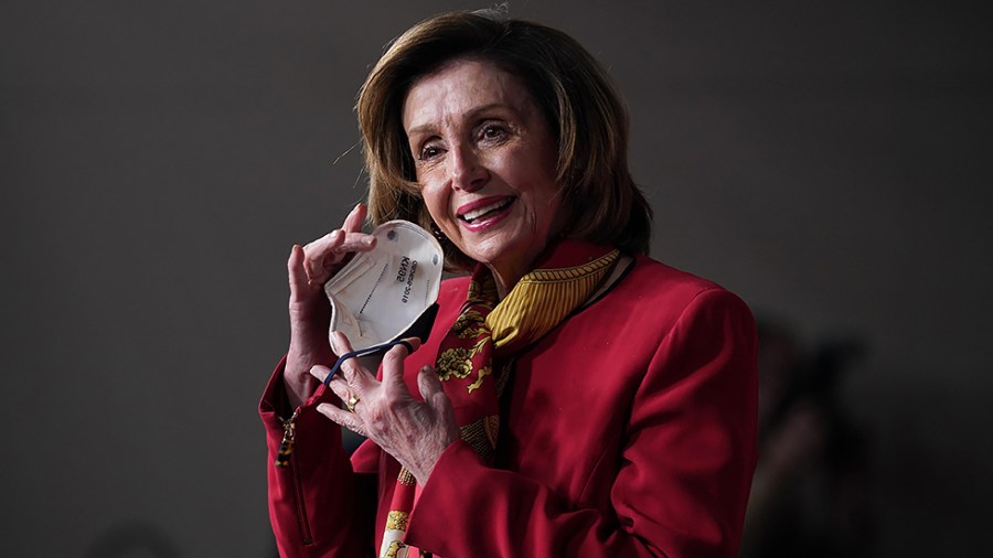 Speaker Nancy Pelosi (D-Calif.) removes her mask as she arrives for her weekly press conference on Wednesday, February 9, 2022.