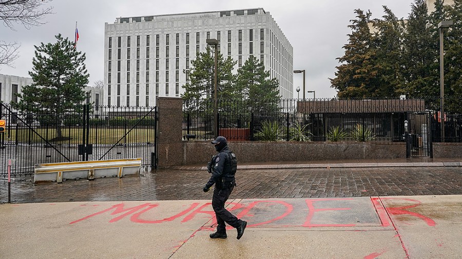 U.S. Secret Service police officer walks past red graffiti painted "Murder" on the ground outside of the Russian Embassy where protestors had gathered to protest the Russian military invasion of Ukraine in Washington D.C., on Thursday, February 24, 2022.