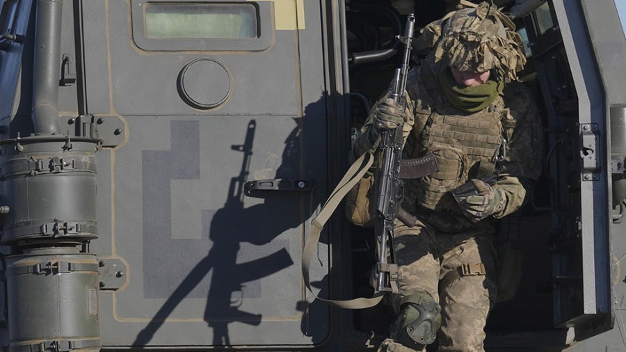 Ukraine serviceman exits a combat vehicle during an exercise