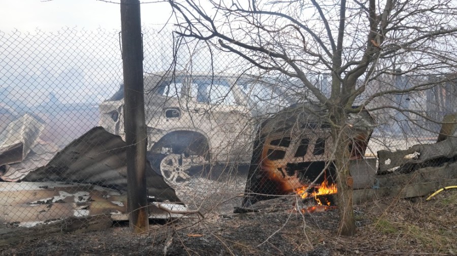 A view of the debris of a privet house and a burned car in the aftermath of Russian shelling, outside Kyiv, Ukraine