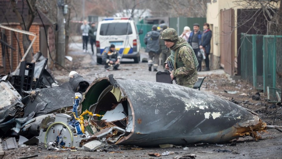 A Ukrainian Army soldier inspects fragments of a downed aircraft in Kyiv, Ukraine, Friday