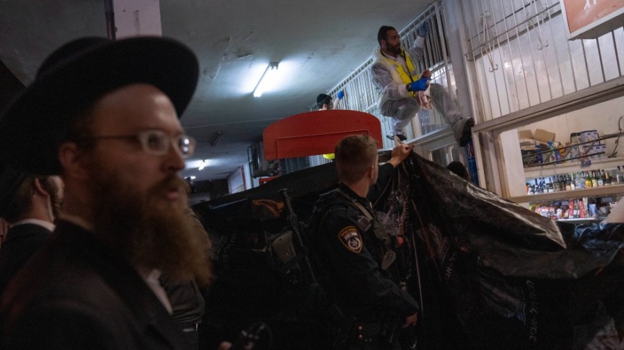 A member of Israeli Zaka Rescue and Recovery team cleans blood from the site where a gunman opened fire in Bnei Brak, Israel