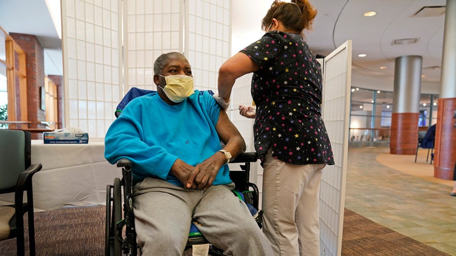 A resident at the Hebrew Home at Riverdale receives a COVID-19 booster shot