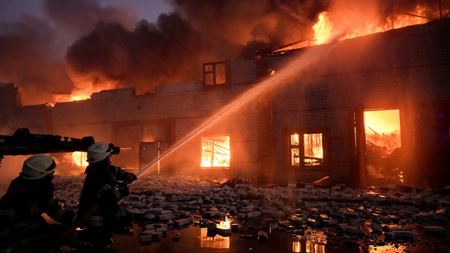 Ukrainian firefighters extinguish a blaze after a bombing on the outskirts of Kyiv, Ukraine