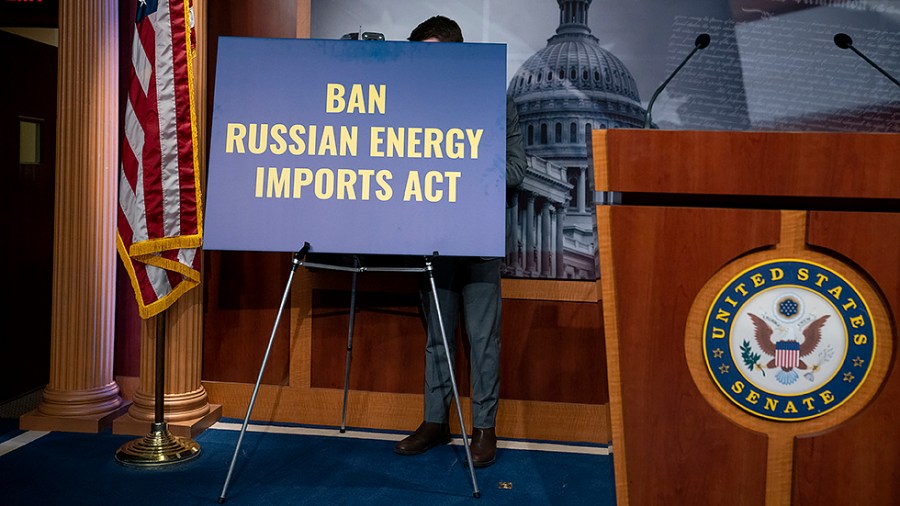 A staffer for Sen. Joe Manchin (D-W.Va.) places a sign prior to a press conference to introduce the Banning Russian Energy Imports Act on Thursday, March 3, 2022.