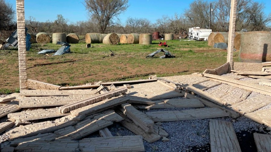 Debris lines the roads as crews and homeowners work to repair properties damaged by severe weather in Elgin, Texas