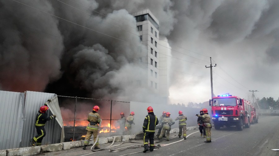 Firefighters work to extinguish a fire at a damaged logistic center after shelling in Kyiv, Ukraine