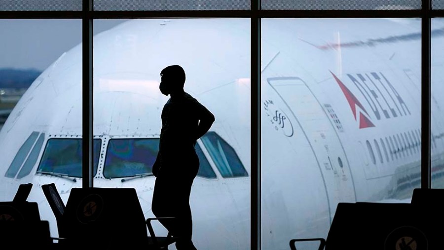 A passenger wears a face mask in the airport