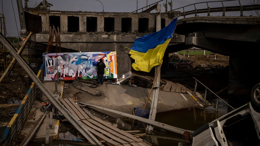 An artist paints a mural in wreckage near Kyiv, Ukraine