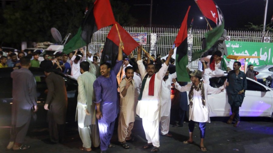 Supporters of an opposition party celebrate the success of a no-confidence vote against Prime Minister Imran Khan, in Karachi, Pakistan