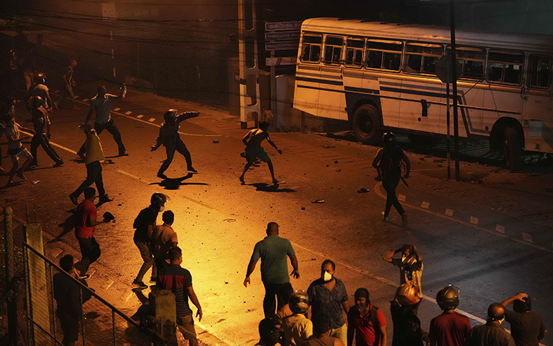 Sri Lankans riot during nighttime as they face a bus