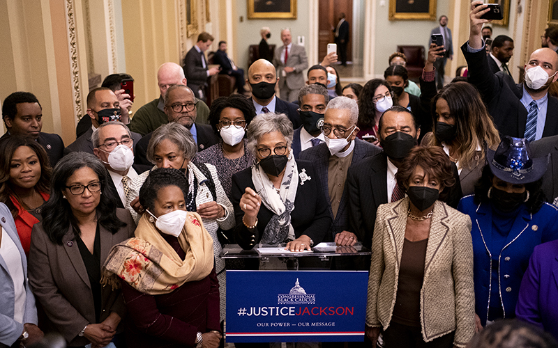 Members of the Congressional Black Caucus make a statement at a podium with a blue sign that says #JusticeJackson