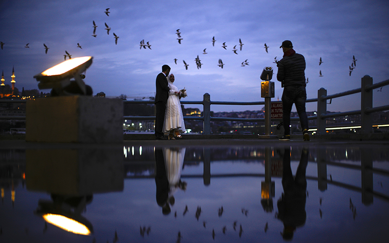 A young couple pose at night as birds pass