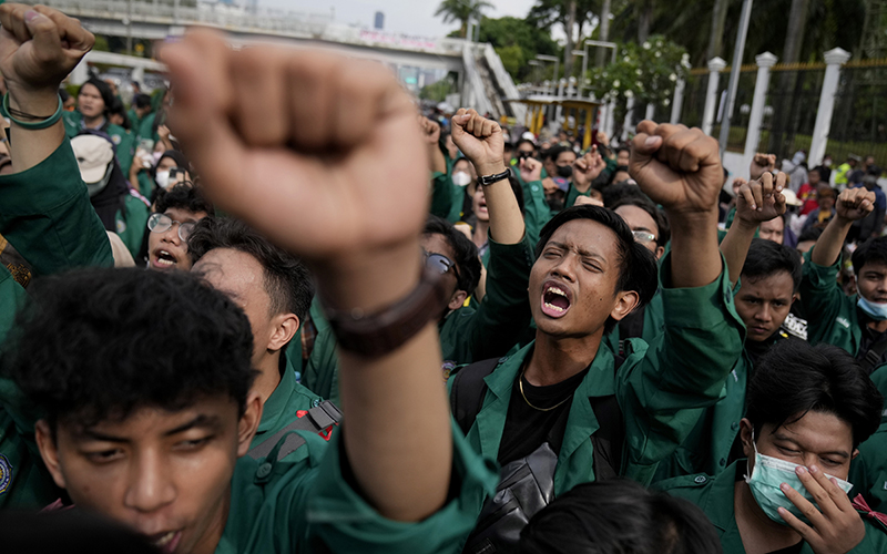 Protesters shout slogans and raise their fists during a rally outside the parliament in Jakarta, Indonesia