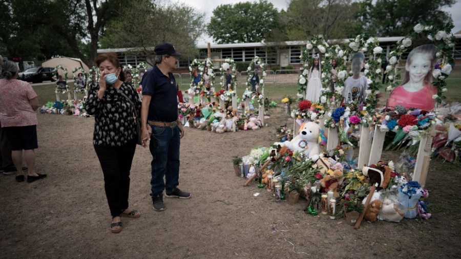 People visit a memorial outside Robb Elementary School in Uvalde, Texas