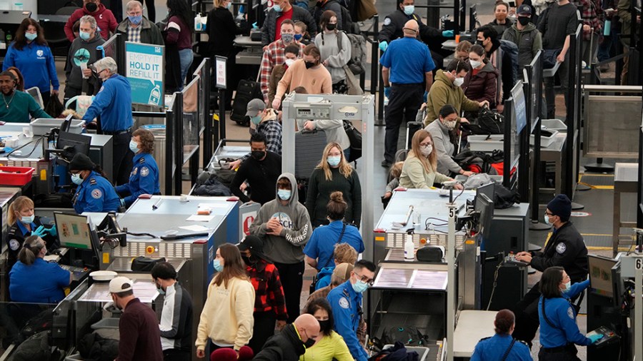 Airline passengers queue up to pass through the security checkpoint