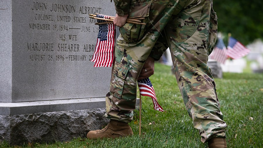 Flags are placed in front of more than 280,000 headstones of U.S. military personnel buried at Arlington National Cemetery, in preparation for Memorial Day, in Arlington, Va., on Thursday, May 26, 2022.