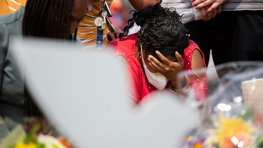 A woman mourns during a moment of silence for the victims of the Buffalo supermarket shooting