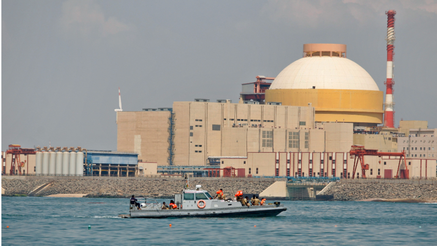 A nuclear power plant with a white dome sits near a body of water.