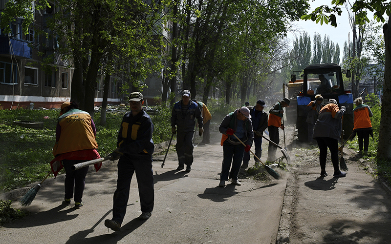 Municipal workers clean the grounds